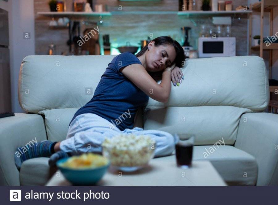 portrait-of-woman-sleeping-on-couch-in-living-in-front-of-television-tired-exhausted-lonely-sl...jpg